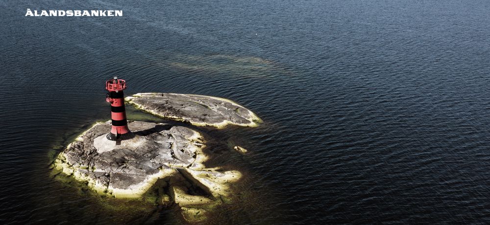 Fyr på ö omringad av vatten och Ålandsbankens logo