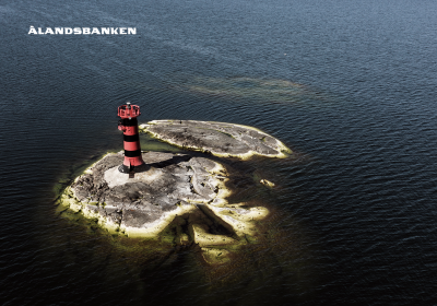 Fyr på ö omringad av vatten och Ålandsbankens logo