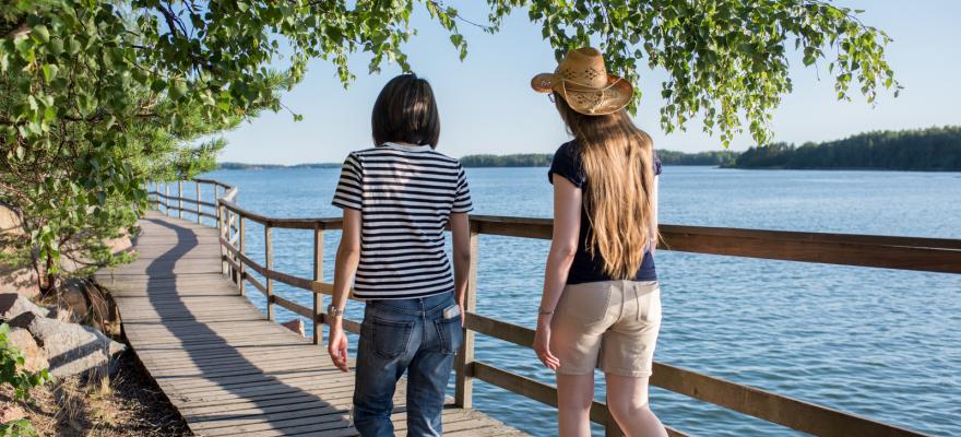 Två personer promenerar längs strandpromenaden i Mariehamn