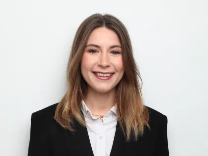Iris Höglander i svart kavaj och vit skjorta mot ljus bakgrund